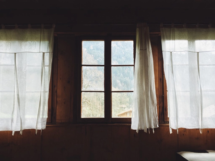 des rideaux blancs accrochés à une fenêtre