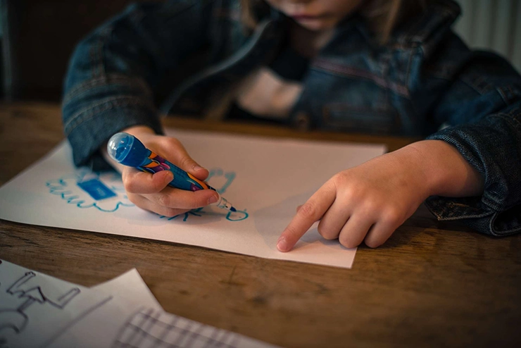 enfant qui dessine sur une feuille